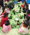 Các trẻ ở Trường Mầm non tư thục Đồ rê mí (phường Cao Thắng, TP Hạ Long) học gói bánh chưng.
