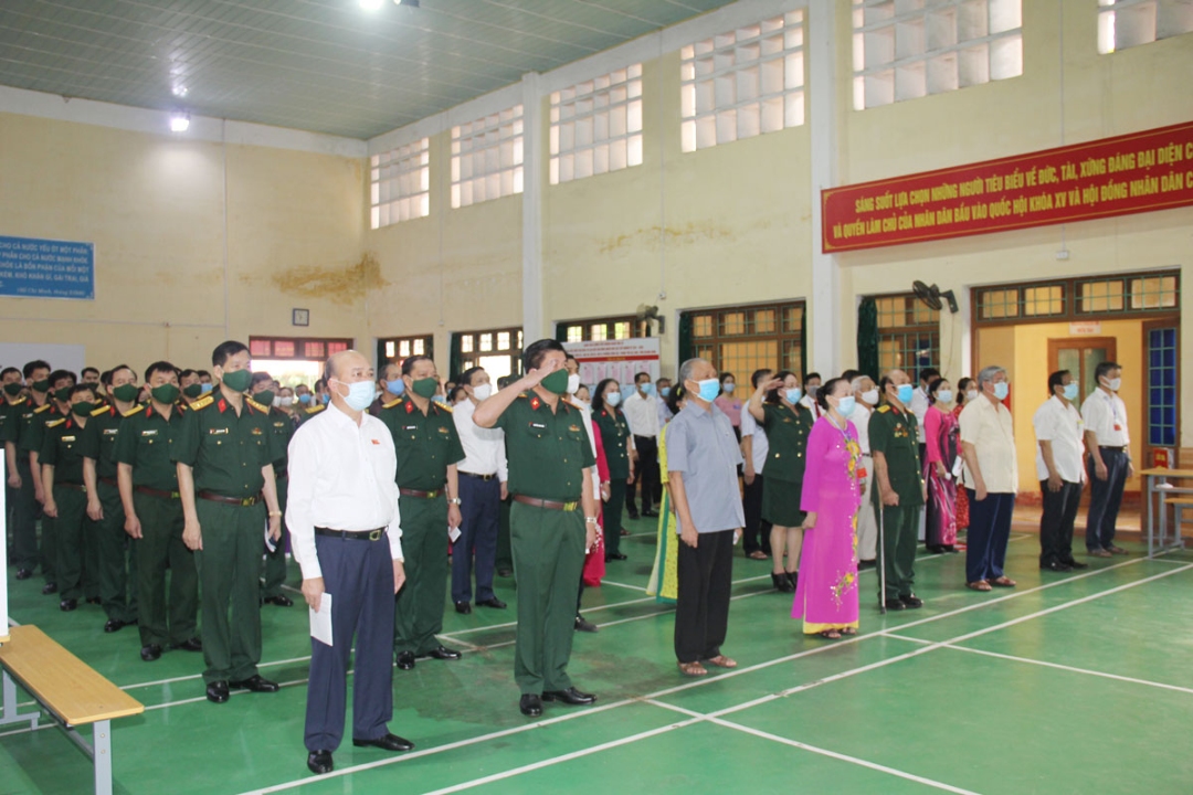 Các đại biểu và cử tri Khu vực bỏ phiếu số 5, phường Hồng Hải, TP Hạ Long thực hiện nghi thức chào cờ