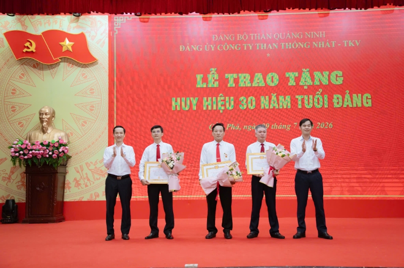 Đồng chí Vương Minh Thu - Bí thư Đảng ủy, Giám đốc Công ty và đồng chí Đào Văn Chính -  Phó Bí thư Đảng ủy Công ty trao Huy hiệu 30 năm tuổi Đảng, tặng hoa chúc mừng 03 đảng viên. Ảnh: Tống Đăng Tiến